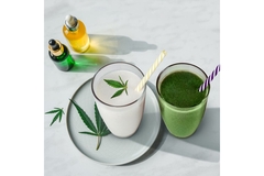 A green and a white beverage with marihuana leaf and CBD bottles.